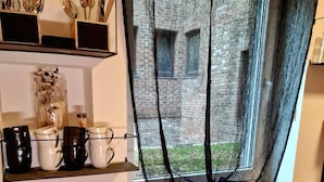 A kitchen with various utensils, bowls, and jars on shelves and counters. - City Hotel Storch (Cologne)