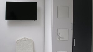 A bathroom with a black toilet, a white sink, and a towel hanging on the wall. - Hotel Kap (Amsterdam)