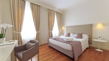 Een hotelkamer met een bed, nachtkastje, stoel en gordijnen.