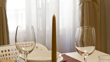 A dining table set with plates, glasses, and a candle.