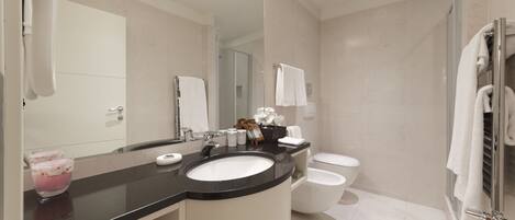 A modern bathroom with a black countertop sink, a glass shower enclosure, and a white toilet.