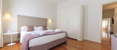 Une chambre d’hôtel moderne, dotée d’un grand lit, de tables de chevet et d’une armoire.