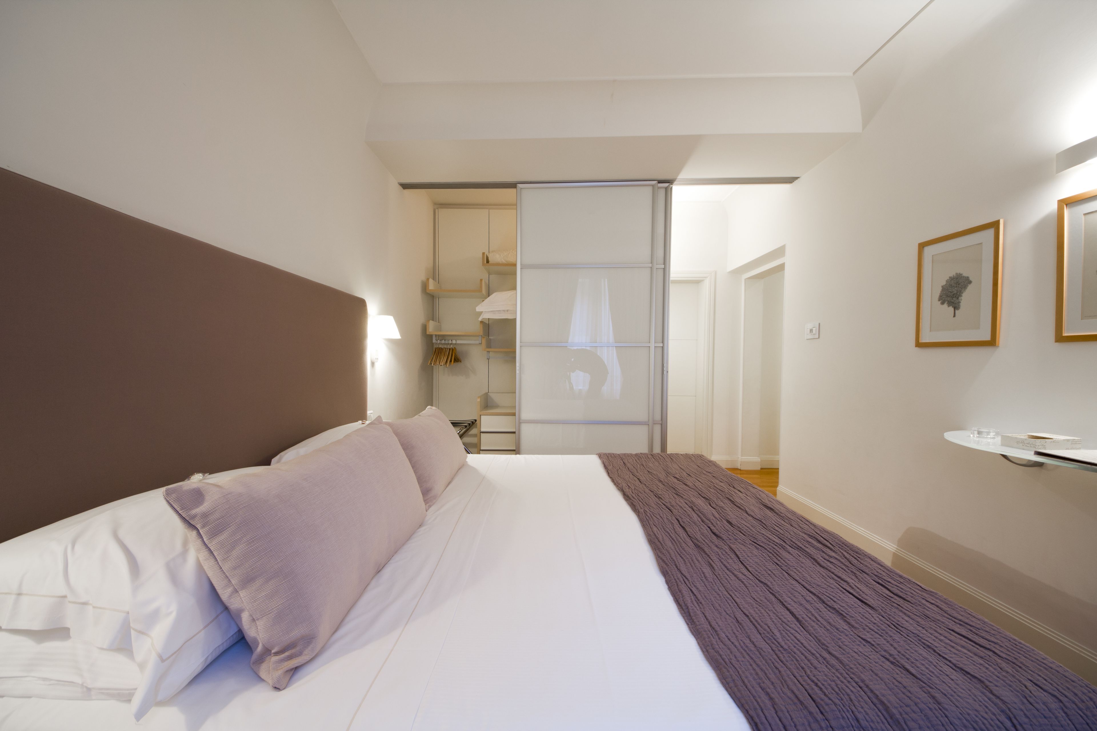 Une chambre à coucher avec un lit, une table de chevet et une armoire.