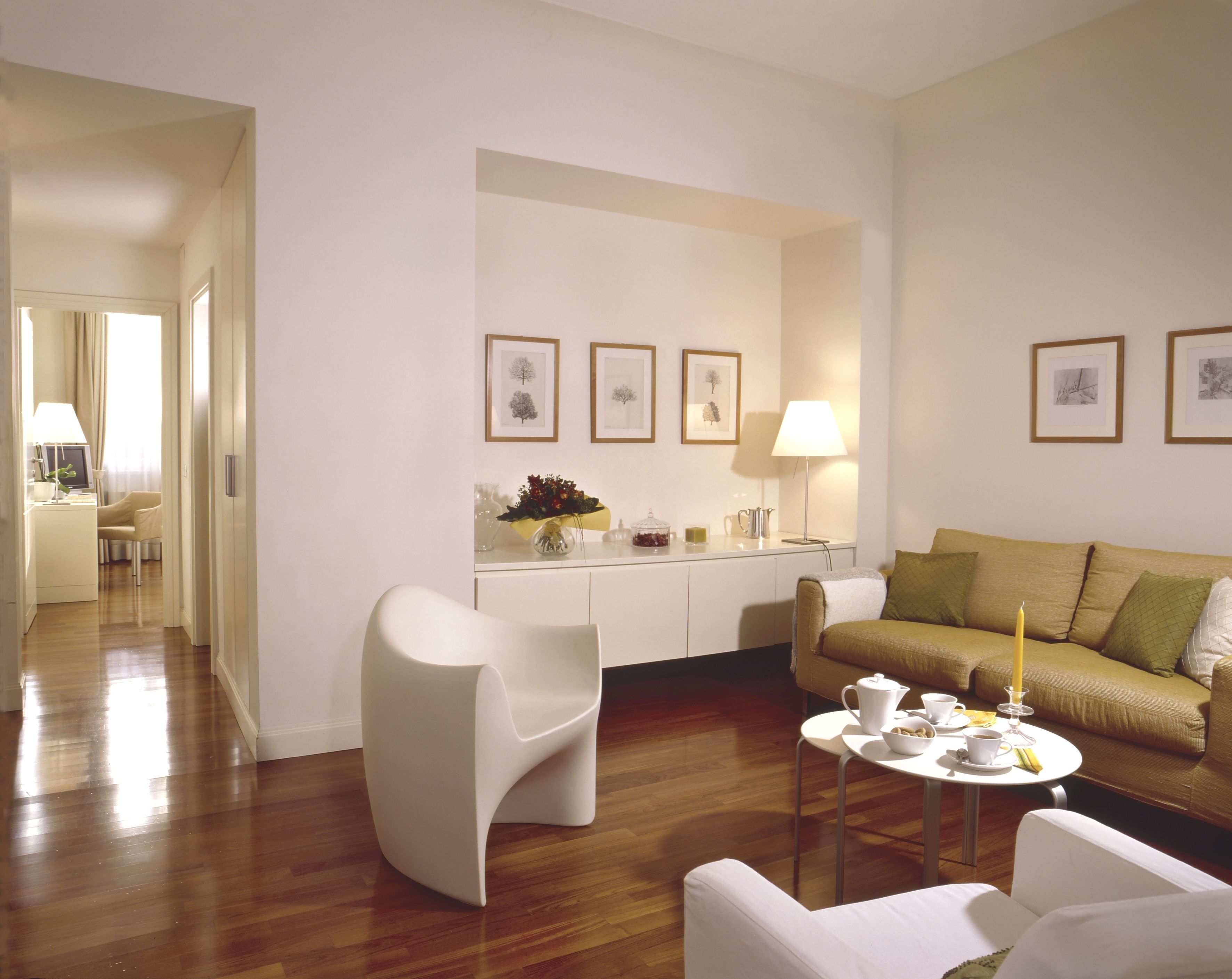 A modern living room with a sofa, chairs, a coffee table, and a dining area with a table and chairs.