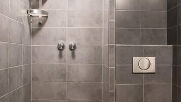 A modern bathroom with a shower, toilet, and two towel racks.