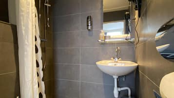 A modern bathroom with a shower, toilet, and sink.