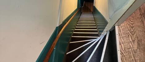 A staircase with a handrail and a wooden handrail on the left.