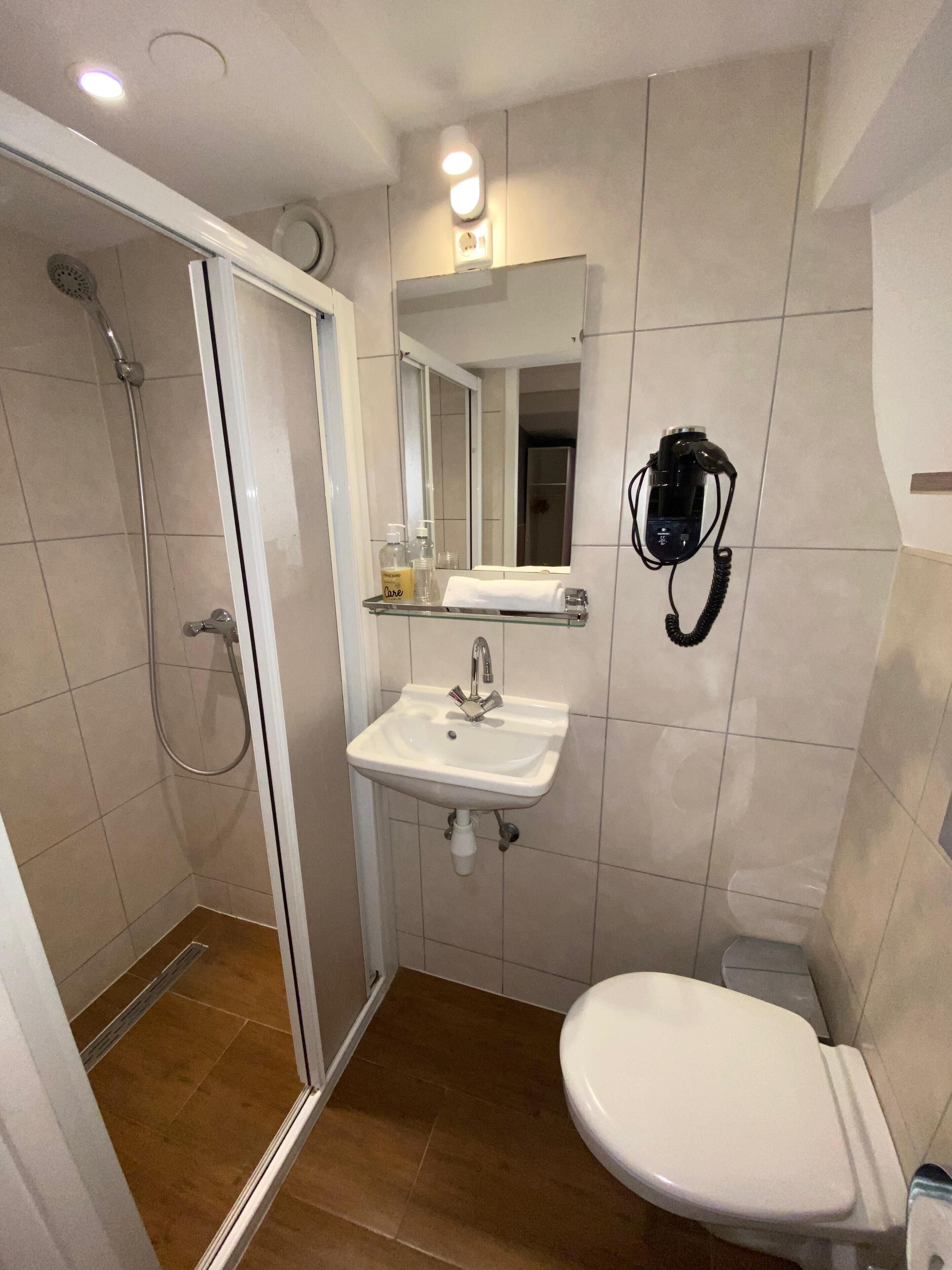 A bathroom with a shower, sink, and toilet.