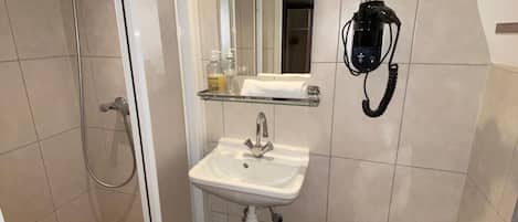 A bathroom with a shower, sink, and toilet.