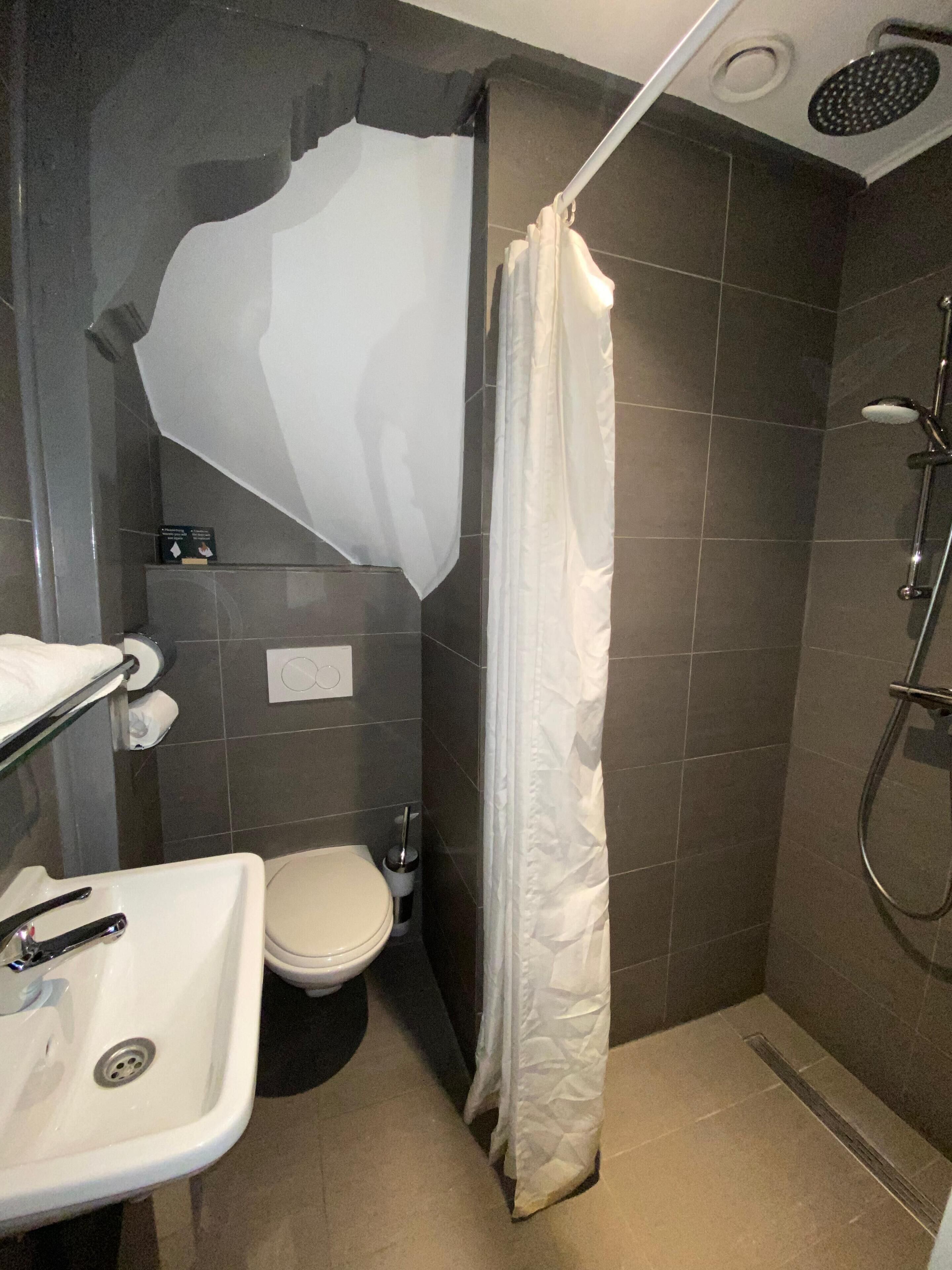 Un baño con ducha, inodoro y lavamanos.