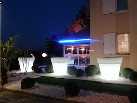 Um edifício com design moderno, fachada de vidro e uma faixa de luz neon azul.