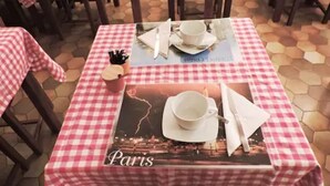 Una mesa con un mantel individual que muestra un paisaje urbano de París, una taza y una servilleta.
