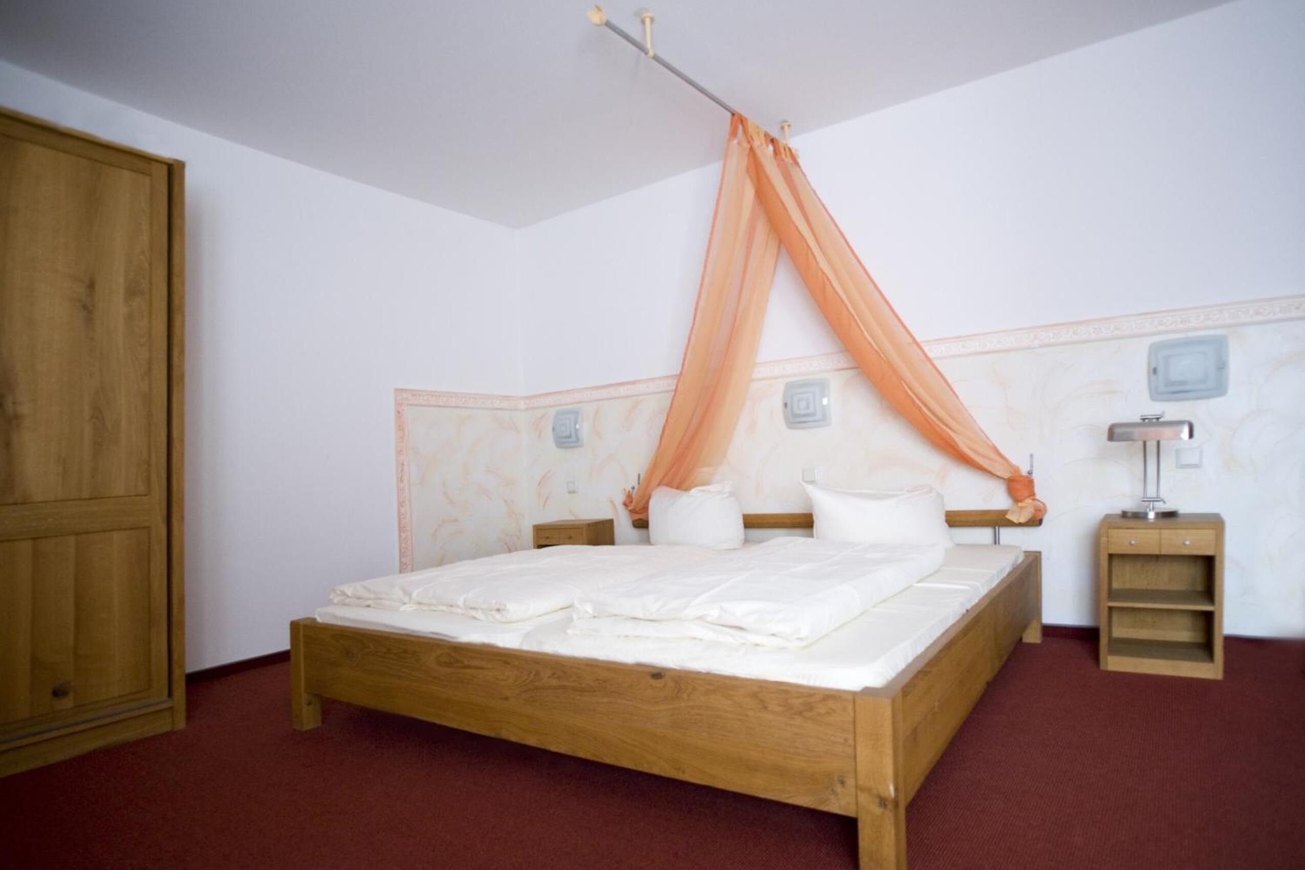 Ein Schlafzimmer mit einem hölzernen Bett, einem Nachttisch und einem Kleiderschrank.