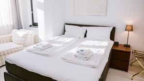 A hotel room with a bed, a bedside table, a lamp, and a window with curtains. - Boutique Hotel Villa Oberkassel (Düsseldorf)