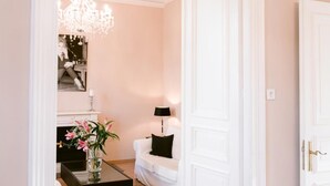 A hallway with a white door, a black coffee table with a vase, and a white sofa with a black cushion. - Boutique Hotel Villa Oberkassel (Düsseldorf)