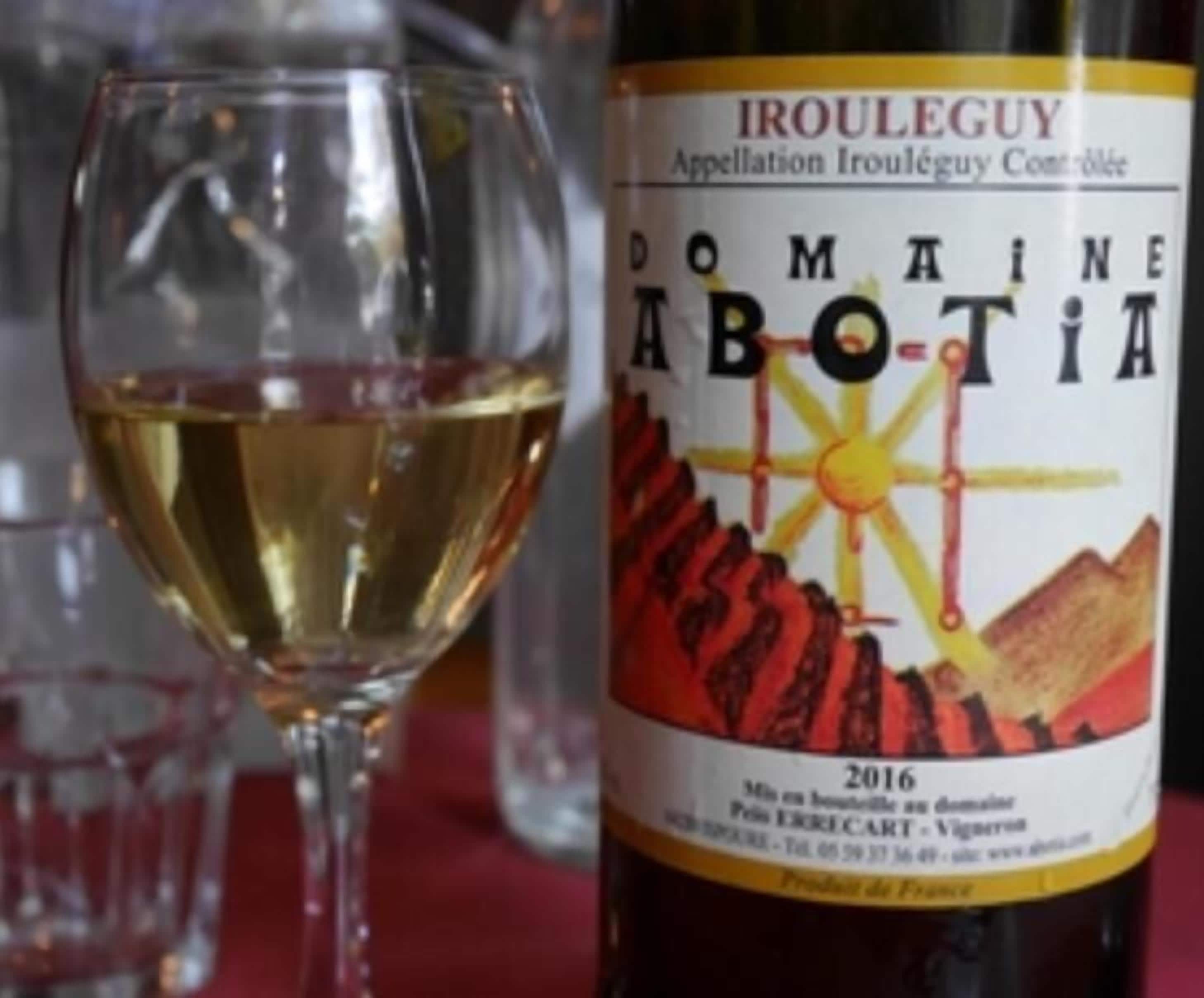 Eine Flasche Domaine Abotia Wein aus dem Jahr 2016 mit einem Etikett, das Sonne und Berge zeigt.