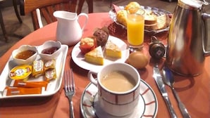 Un desayuno con una mesa, sillas y una planta en maceta.