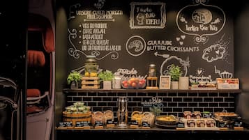Un bufé de desayuno con diversos alimentos y una pizarra con texto.