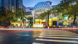 A modern building with a distinctive dome structure, a crosswalk in front, and a well-lit facade. - Nan Guo Hotel Guangzhou (Guangzhou)