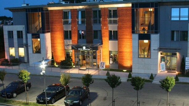 A modern hotel with a prominent entrance, multiple parking spaces, and a well-lit facade. - Hotel Kuracyjny (Gdynia)