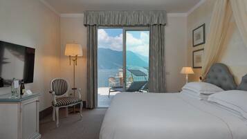 Habitación de hotel con cama, una silla, un escritorio, una lámpara y vista al mar.