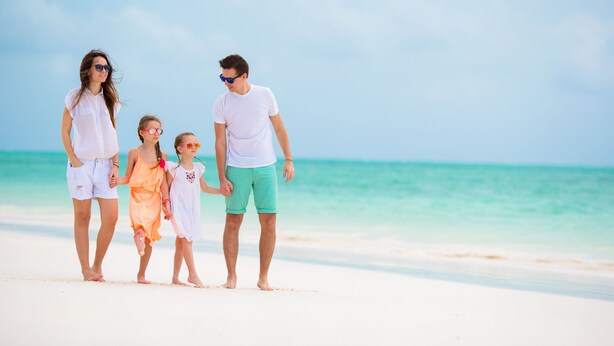 A family walking on a beach with clear skies and calm waters. - Hotel Miramare (Mondolfo)