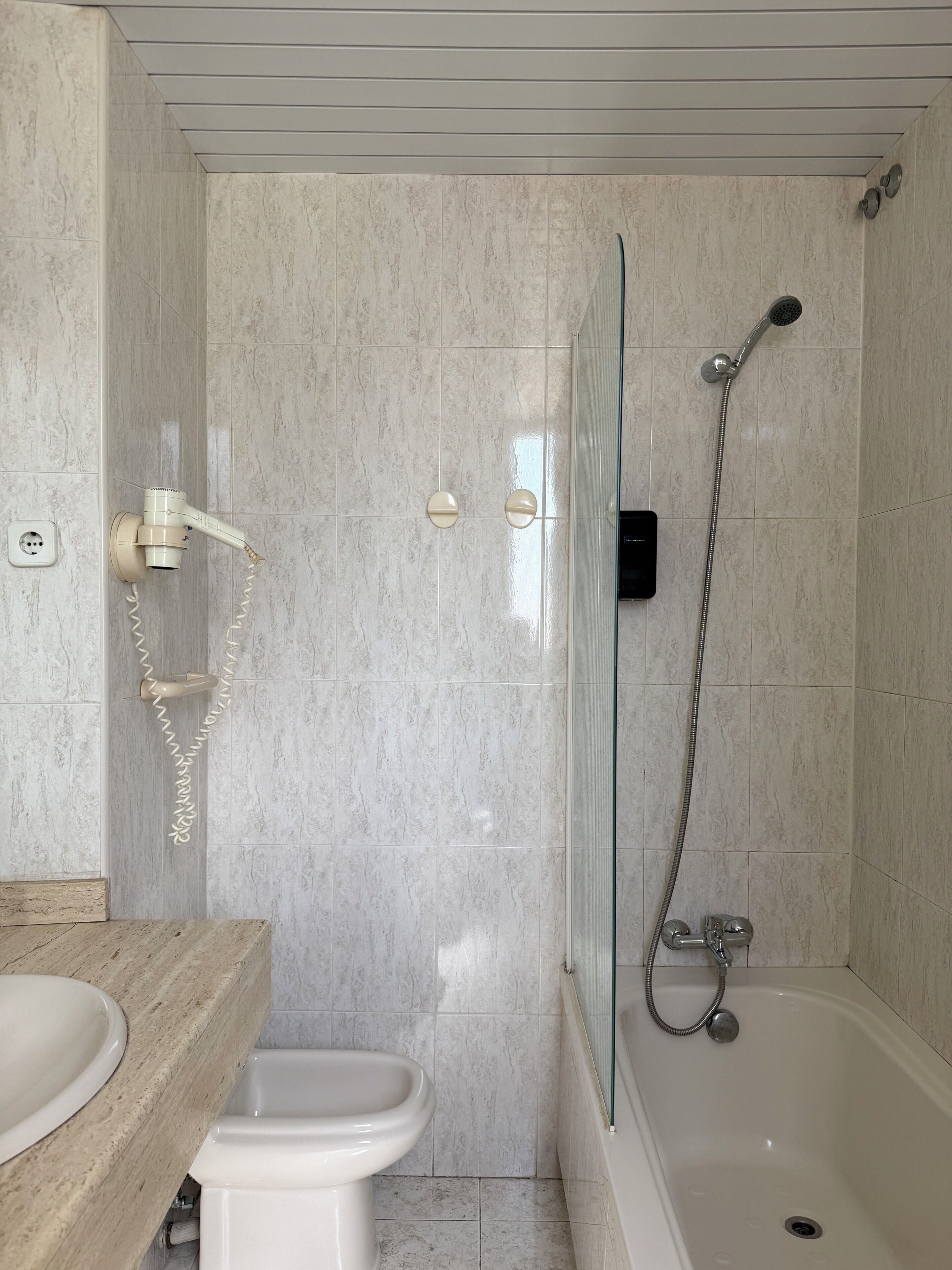 A bathroom with a shower, toilet, and sink.