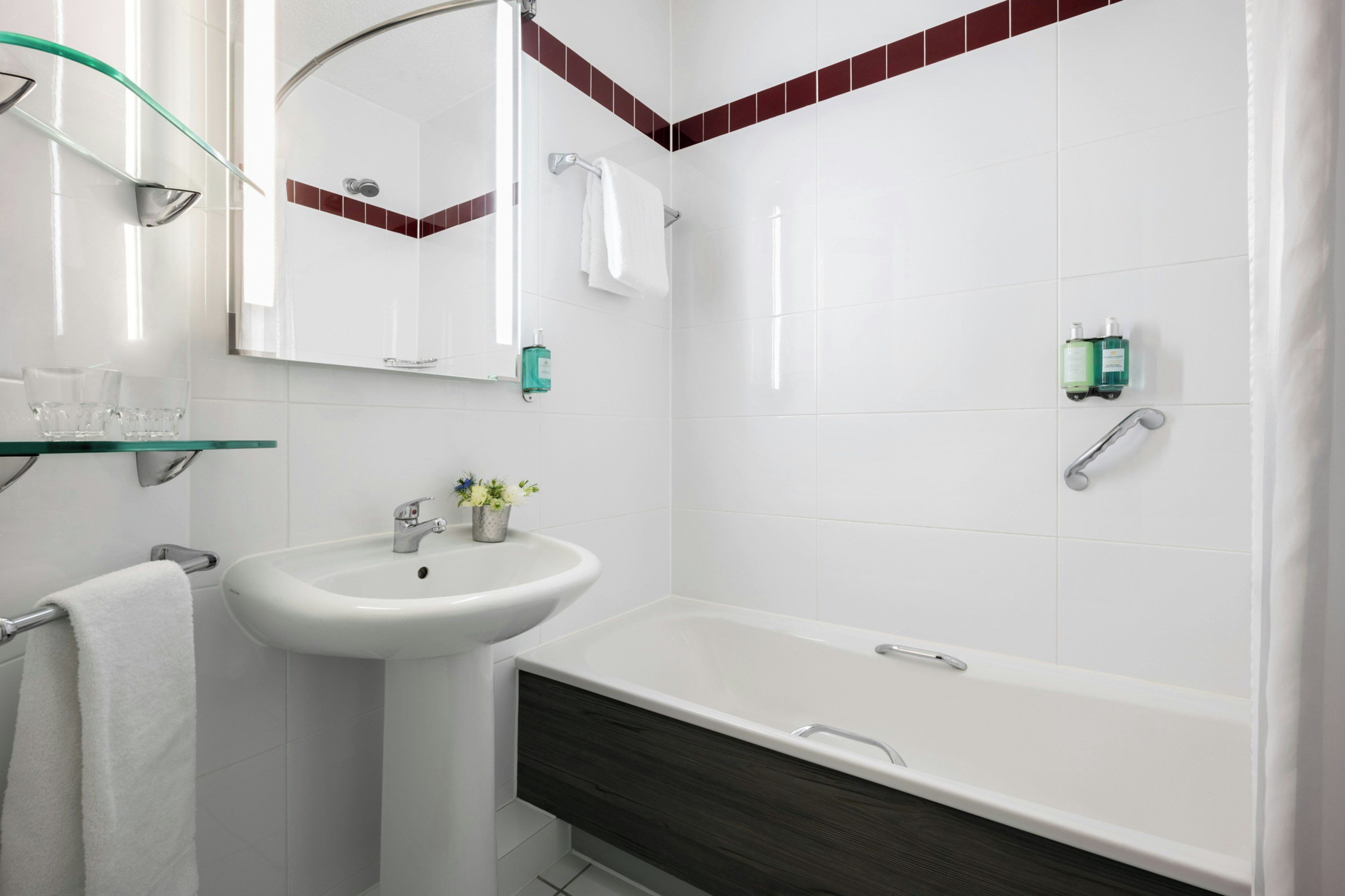 A modern bathroom with a white sink, a glass shower enclosure, a bathtub, and a mirror.