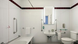 A modern bathroom with a bathtub, toilet, and sink.
