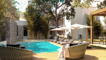 Alberca al aire libre y camastros