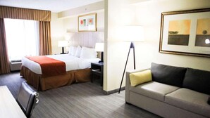 A hotel room with a bed, a sofa, a desk, and a lamp. - Country Inn & Suites by Radisson, Chester, VA (Chester)