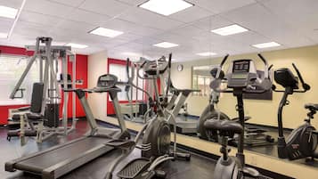 Un gimnasio con cintas de correr, elípticas y máquinas de pesas.