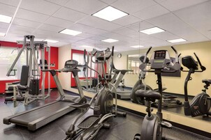 Un gimnasio con cintas de correr, elípticas y máquinas de pesas.