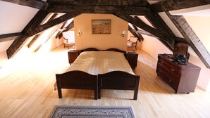 A bedroom with a wooden ceiling, a bed, a dresser, and a painting on the wall. - Hotel King George (Prague)