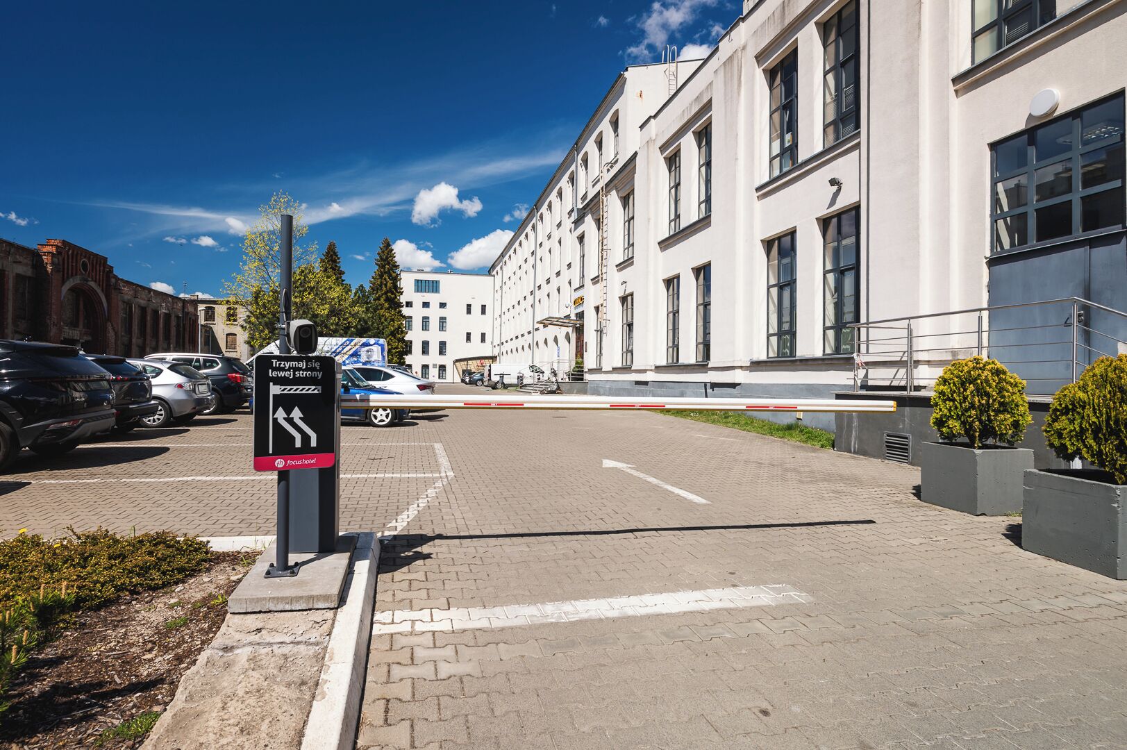 A parking area with a sign indicating directions to a hotel.