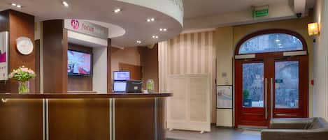 A reception area with a curved desk, a clock, and a reception sign.