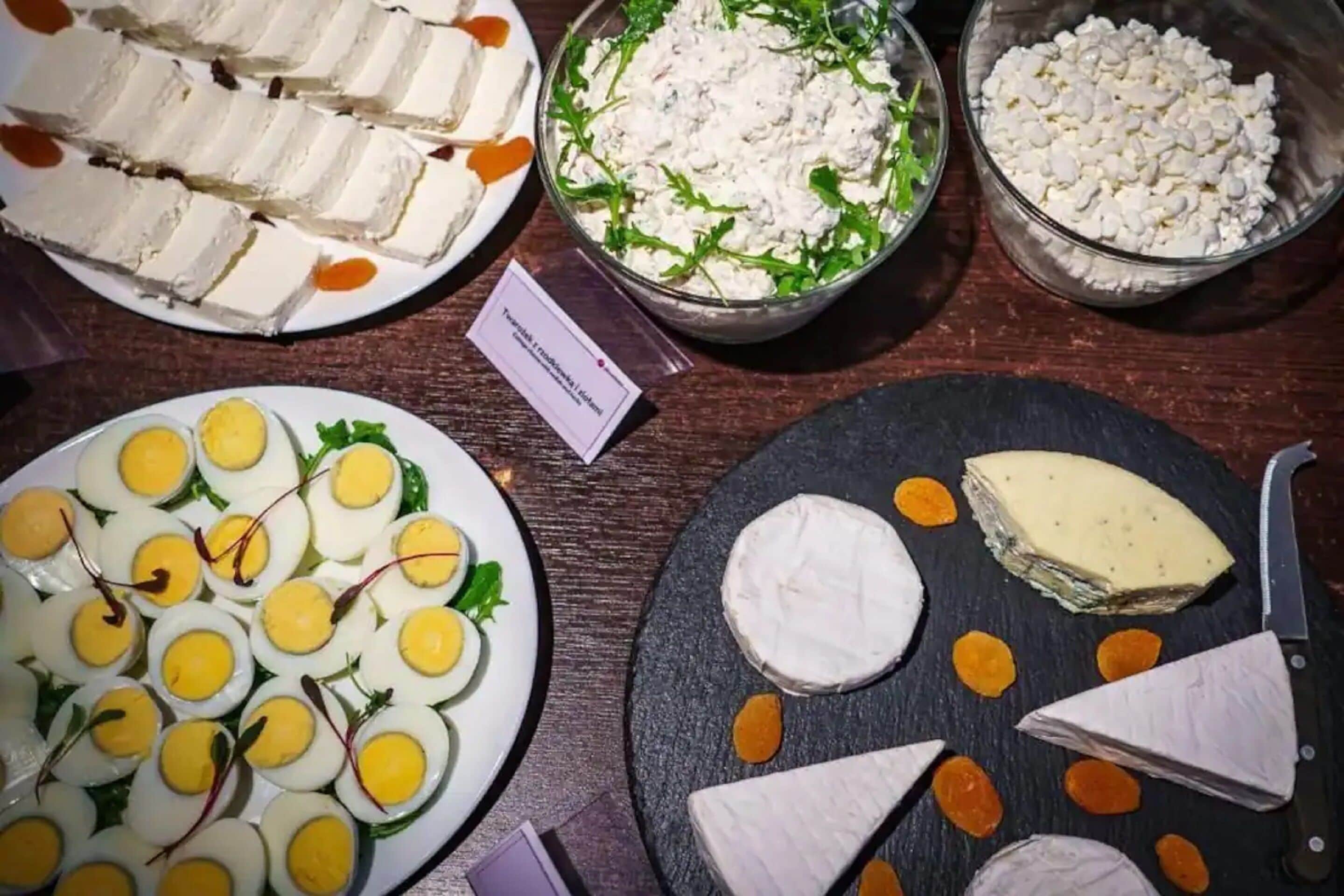 A variety of food items including sliced cheese, a bowl of salad, and a plate of deviled eggs.