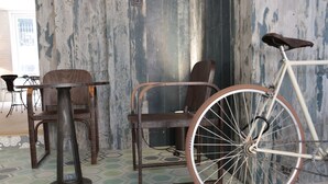Un intérieur rustique avec un vélo, des chaises en bois et une table.