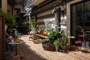 Eine Holzterrasse mit Sitzgelegenheiten im Freien, Pflanzkübeln und einem Esstisch.