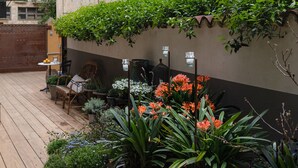 Un bâtiment doté de nombreuses fenêtres et d’un balcon orné de plantes en pot.