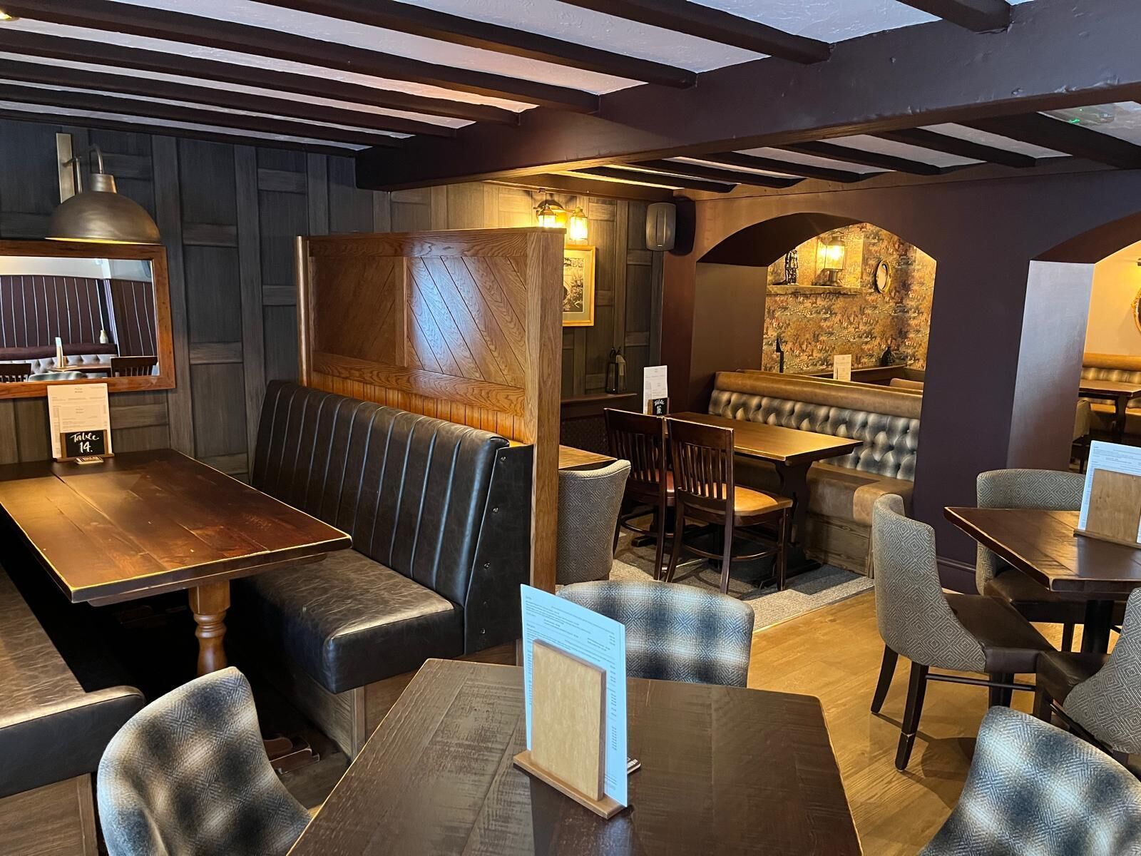 A restaurant interior with booths, tables, and a bar area.