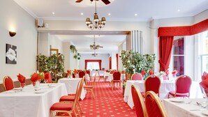 A hotel dining area with tables set for service, red carpet flooring, and red and gold chairs. - Old Rose and Crown Hotel (Birmingham)