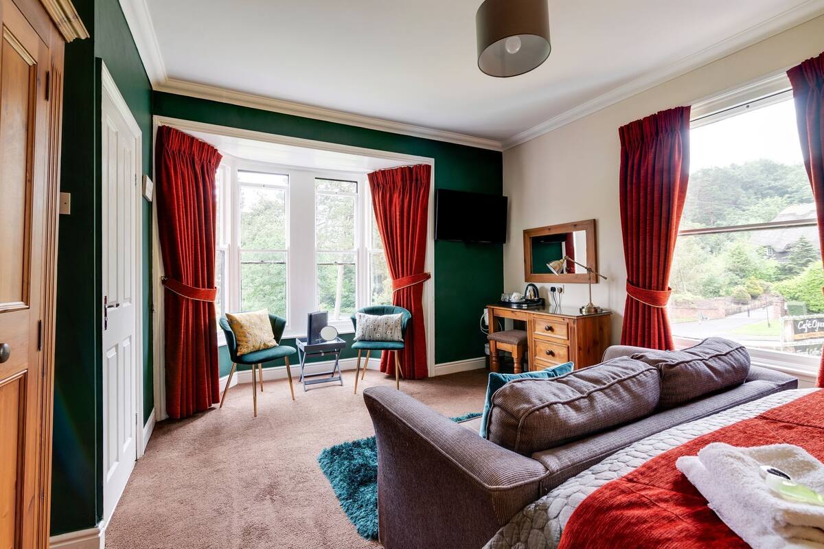 A room with a bed, a desk, a chair, and a TV.