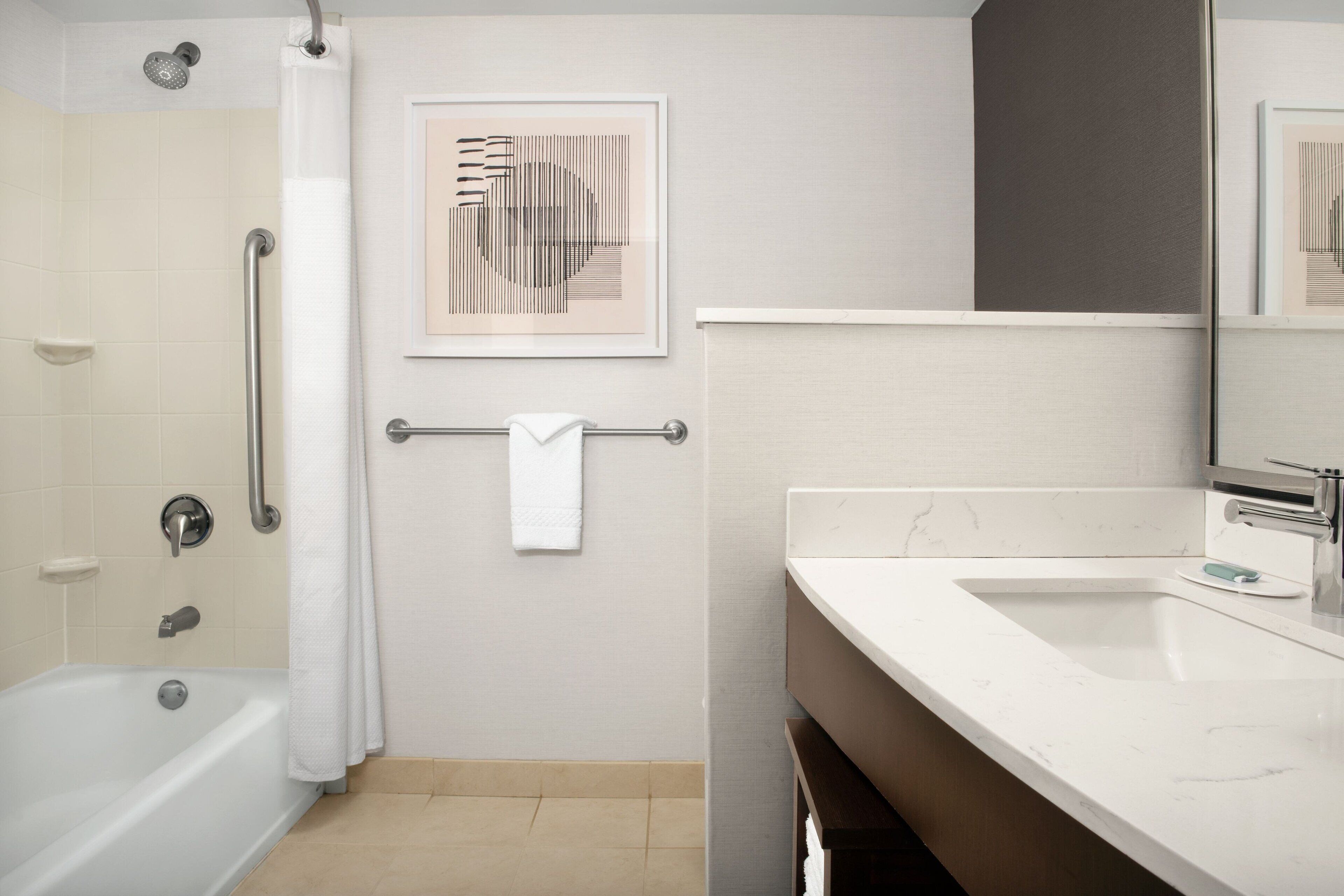 combined shower/bathtub, designer toiletries, hair dryer, towels