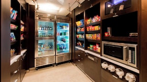A well-lit kitchen area with stainless steel appliances, including a refrigerator, microwave, and a sink.