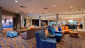 A spacious lobby with multiple seating areas, a bar, and a dining area.