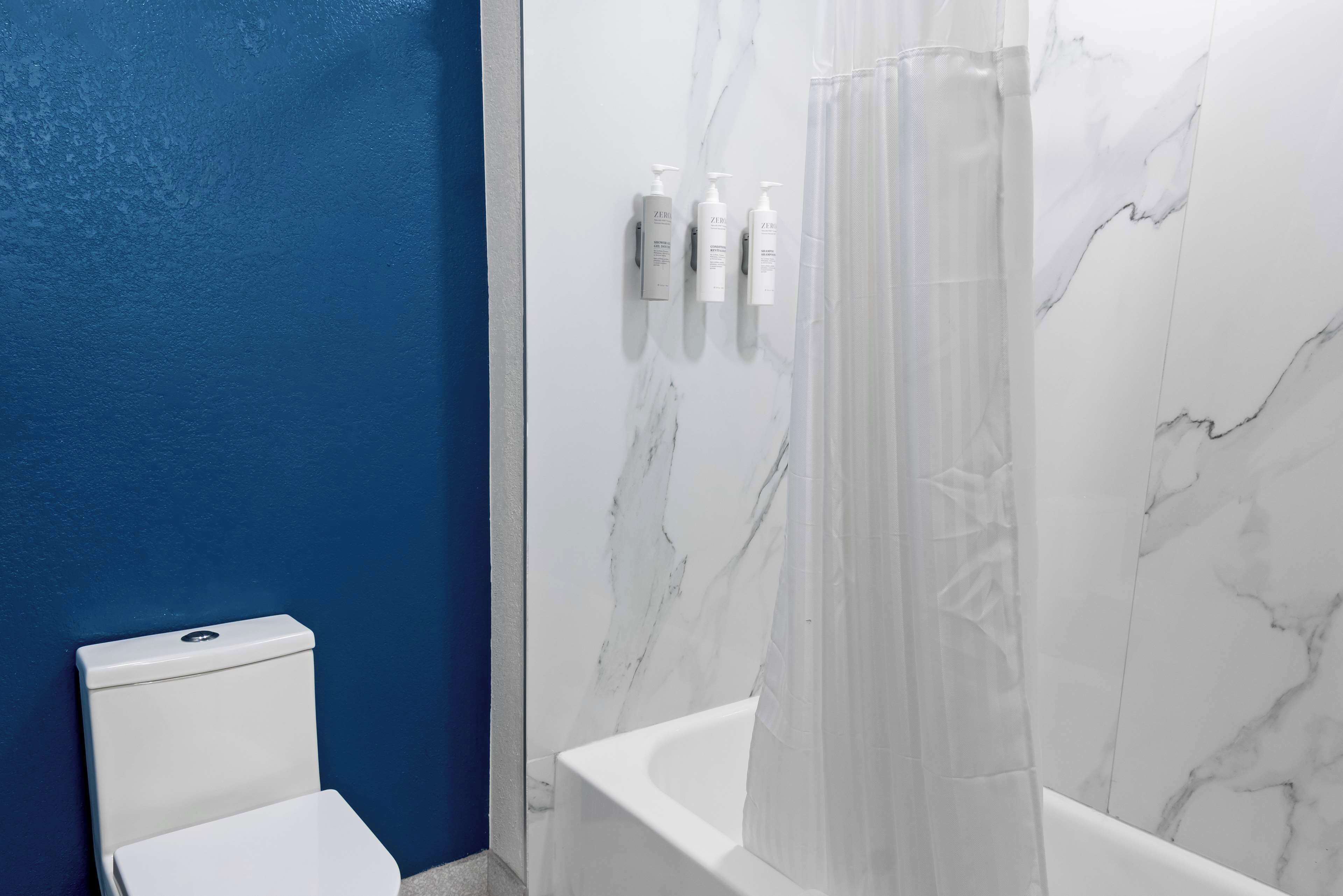 Ein Badezimmer mit Toilette, Badewanne und Duschvorhang.