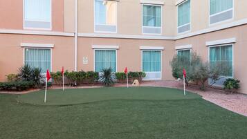 Stroll through the beautifully manicured courtyard, featuring a lush lawn and a scenic golf course.