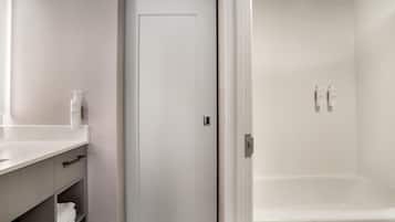 A bathroom with a white sink, mirror, and toiletries.