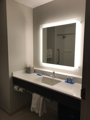 A modern bathroom with a large mirror, a sink, and a towel rack. - Holiday Inn Express Hotel & Suites Canton by IHG (Canton)